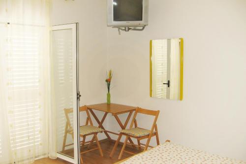 a room with a table and two chairs and a mirror at Apartments and rooms with parking space Bol, Brac - 2878 in Bol