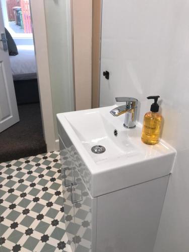 a bathroom with a white sink and a mirror at 1Bed Golfhill Cottage in Dunblane