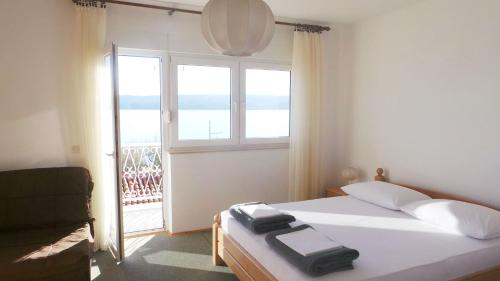 a bedroom with a bed and a large window at Apartments by the sea Duce, Omis - 2829 in Duće