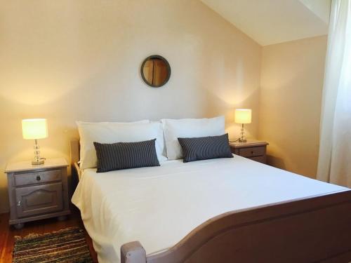 Un dormitorio con una gran cama blanca con dos lámparas. en Seaside family friendly house with a swimming pool Cove Osibova, Brac - 2837, en Milna