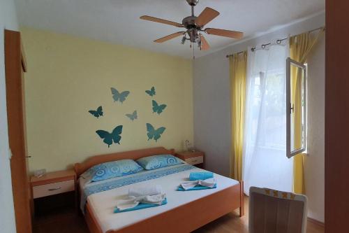 sypialnia z łóżkiem z motylami na ścianie w obiekcie Apartments with a parking space Postira, Brac - 2911 w Postirze