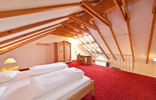 デュッセルドルフにあるノヴム ホテル マディソン デュッセルドルフ ハウプトバーンホフの赤いカーペットフロアのベッドルーム1室(ベッド2台付)