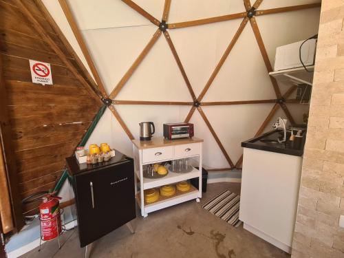 a room with a small kitchen in a yurt at Domo da Cuesta - Glamping com vista para a montanha in Bofete