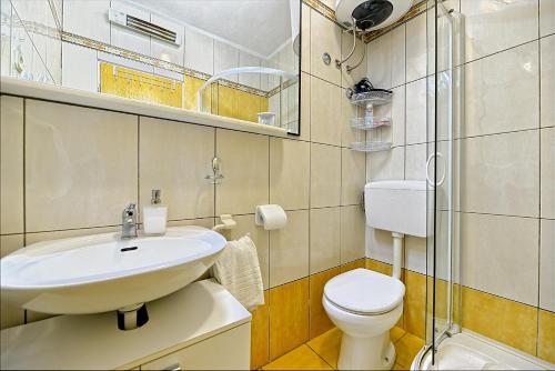 bagno con lavandino bianco e servizi igienici di Apartments with a parking space Postira, Brac - 2913 a Postira (Postire)