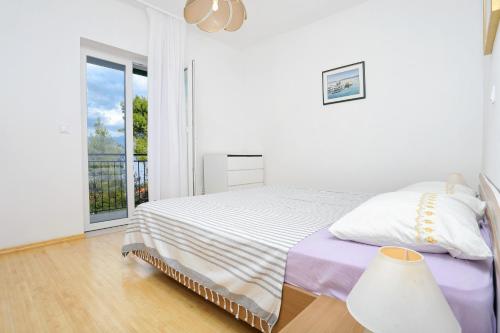 una camera bianca con letto e balcone di Apartments with a parking space Postira, Brac - 2913 a Postira (Postire)