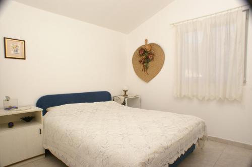 Habitación blanca con cama y ventana en Apartment Vela Farska 2897b en Murvica