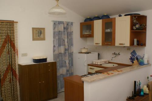 una pequeña cocina con fregadero y nevera. en Apartment Vela Farska 2897b en Murvica