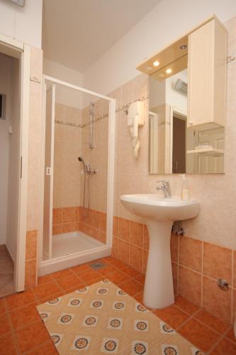 a bathroom with a sink and a shower at Apartments and rooms with WiFi Vrsar, Porec - 3007 in Vrsar
