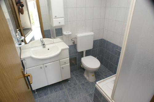 a bathroom with a toilet and a sink and a mirror at Apartments with a parking space Vinisce, Trogir - 2987 in Vinišće