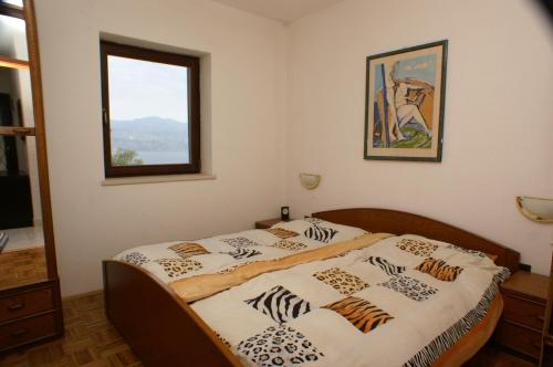 a bedroom with a bed with zebra sheets and a window at Apartments with a swimming pool Splitska, Brac - 2889 in Splitska