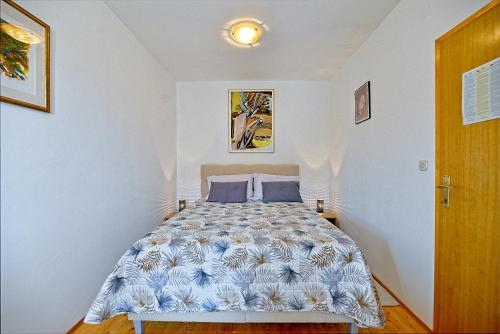 a bedroom with a bed with blue pillows at Apartment Postira 2913b in Postira