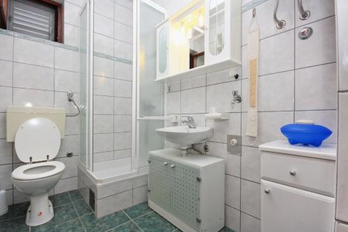Baño blanco con aseo y lavamanos en Isolated apartments with a parking space Cove Vela Farska, Brac - 2897, en Murvica