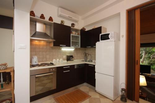 a kitchen with a white refrigerator and a sink at Apartments by the sea Splitska, Brac - 2865 in Postira