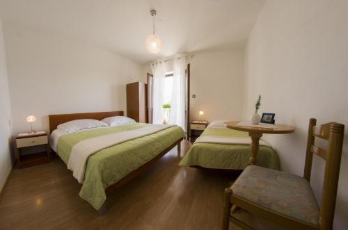 a bedroom with two beds and a table and a window at Apartments by the sea Sumartin, Brac - 2951 in Sumartin