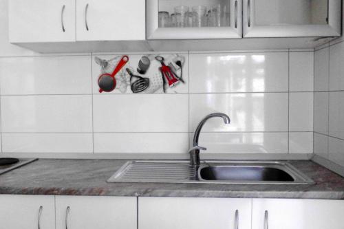 eine Küche mit einem Waschbecken und weißen Schränken in der Unterkunft Apartments with a parking space Bol, Brac - 2879 in Bol