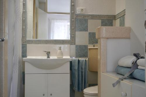 a bathroom with a sink and a mirror and a toilet at Apartments by the sea Pucisca, Brac - 2927 in Pučišća