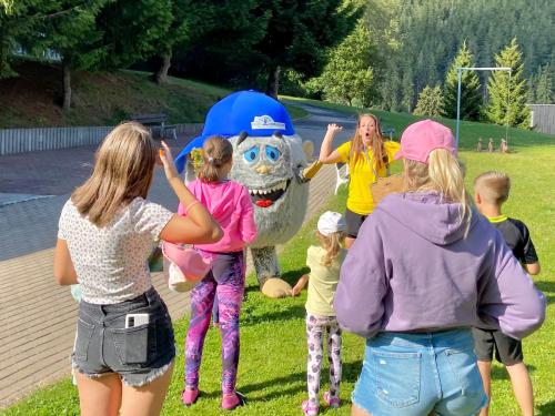 a group of children standing in front of a mascot at Hotel Horizont in Pec pod Sněžkou