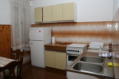 a small kitchen with a sink and a refrigerator at Apartments by the sea Pucisca, Brac - 2942 in Pučišća