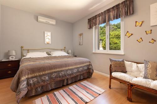 a bedroom with a bed and a window and a couch at Apartments by the sea Sumartin, Brac - 2940 in Sumartin