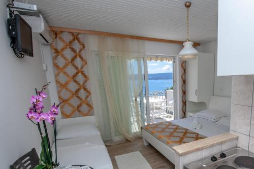 een kleine kamer met een bed en een balkon bij Apartments by the sea Duce, Omis - 2992 in Dugi Rat
