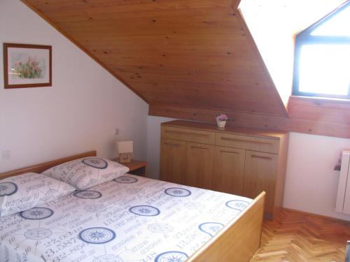 Schlafzimmer mit einem Bett mit Holzdecke in der Unterkunft Apartments by the sea Tribunj, Vodice - 2993 in Tribunj