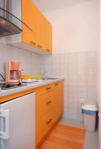 a kitchen with orange cabinets and a stove top oven at Apartments with parking space Vodice - 2995 in Vodice