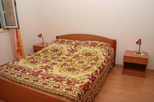 a bedroom with a bed with a flowered blanket on it at Apartments with parking space Bol, Brac - 2884 in Bol