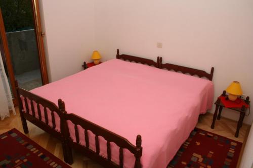 Double Room Sutivan 2943a في سوتيفان: غرفة نوم بسرير كبير مع بطانية وردية