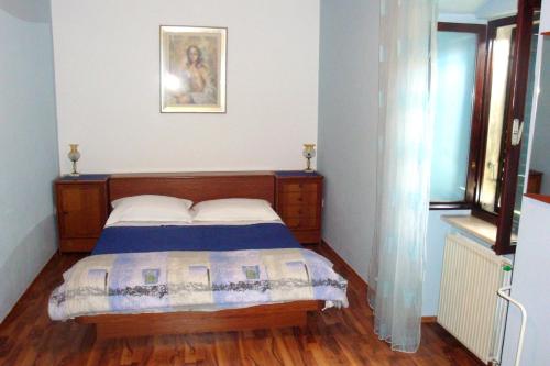 a bedroom with a bed and a picture on the wall at Apartments by the sea Sutivan, Brac - 2946 in Sutivan