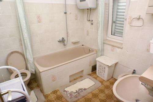 a bathroom with a tub and a toilet and a sink at Apartments with a parking space Splitska, Brac - 2858 in Postira