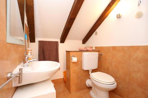 a bathroom with a white toilet and a sink at Apartment Okrug Donji 2977b in Okrug Gornji