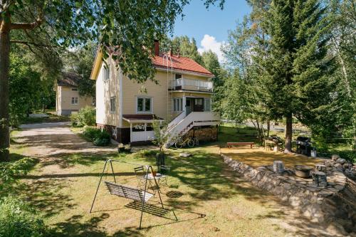 a house with a yard with a swing at Arctic Garden Design Villa in Rovaniemi
