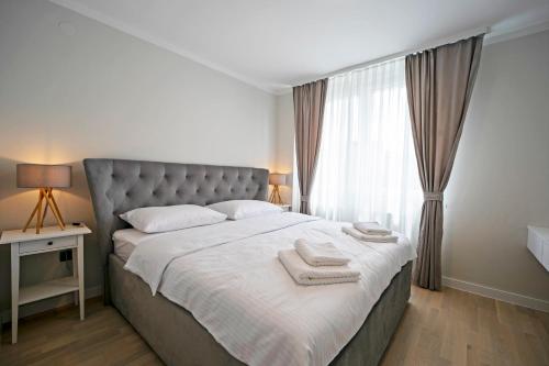 1 dormitorio con 1 cama grande y 2 toallas. en NEW!! High end 2bd modern apartment in Novi Zagreb, en Zagreb