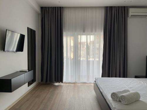 a hotel room with a bed and a television at Ladi Rooms in Tirana