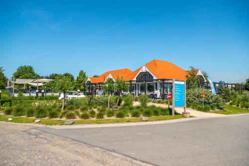a house with an orange roof on the side of a road at EuroParcs Marina Strandbad in Olburgen