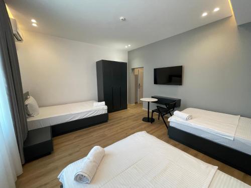 a small room with two beds and a desk at Ladi Rooms in Tirana