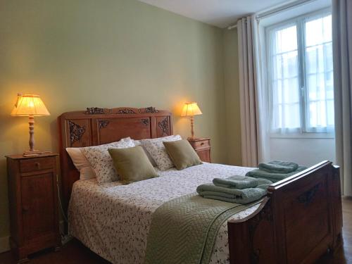 um quarto com uma cama com 2 candeeiros e uma janela em La Belle Vienne em Exideuil