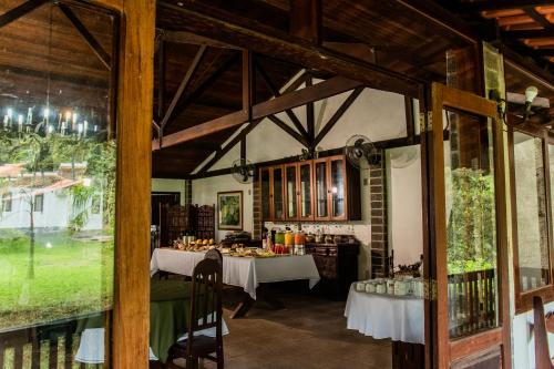 a dining room with two tables in a building at Pousada Tapera in Penedo
