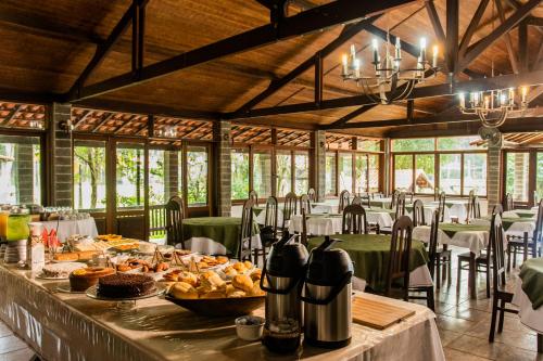 a dining room with a table with food on it at Pousada Tapera in Penedo