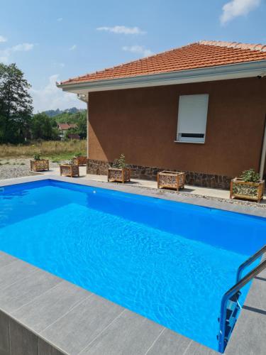 a large blue swimming pool in front of a house at OAZA in Mokra Gora