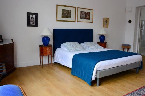 a bedroom with a bed with a blue head board at Hotel Joly in Armentières