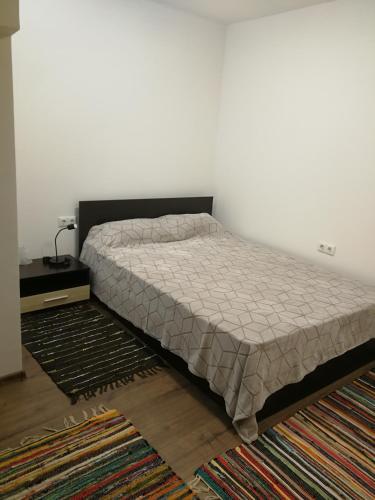 a bed in a bedroom with a white wall at Studio Rayskata yabalka in Varna City