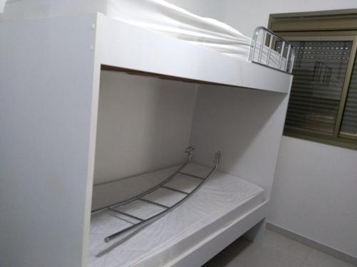 a white bunk bed in a room with a window at Beira Mar Muro Alto no Condomínio Ekoara ap 202 in Porto De Galinhas