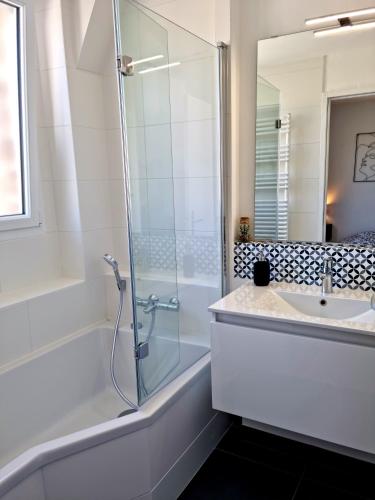 une salle de bain avec une douche en verre et un lavabo dans l'établissement Appartement Cosy Caen, à Caen