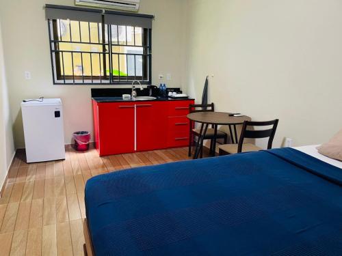 a bedroom with a bed and a table with a red cabinet at Waterland Suites in Paramaribo