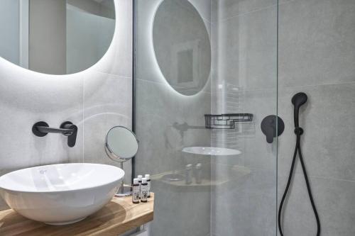 a bathroom with a sink and a glass shower at Sleeping with the Ancient Gods in Koukaki in Athens