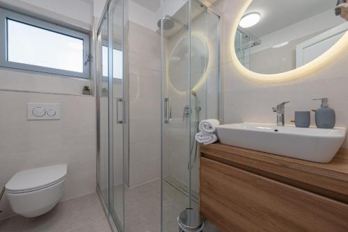 a bathroom with a sink and a glass shower at Apartments Niko in Sukošan