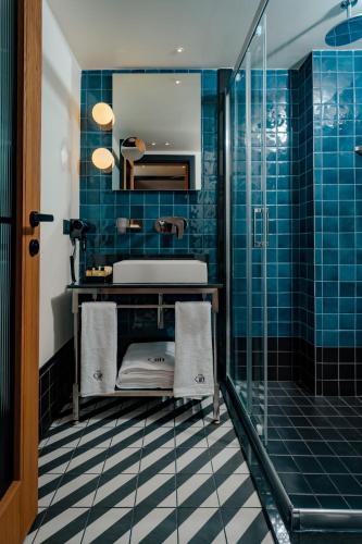 a blue tiled bathroom with a sink and a shower at The Gift Hotel in Istanbul