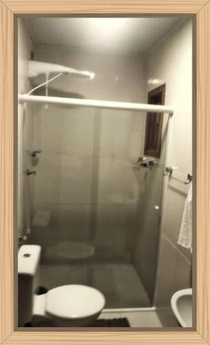 a bathroom with a glass shower with a toilet at RESIDENCIAL RECANTO Do THEOZINHO in Bombinhas