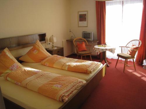 a bedroom with two beds and a table and chairs at Landhaus Mast in Baiersbronn